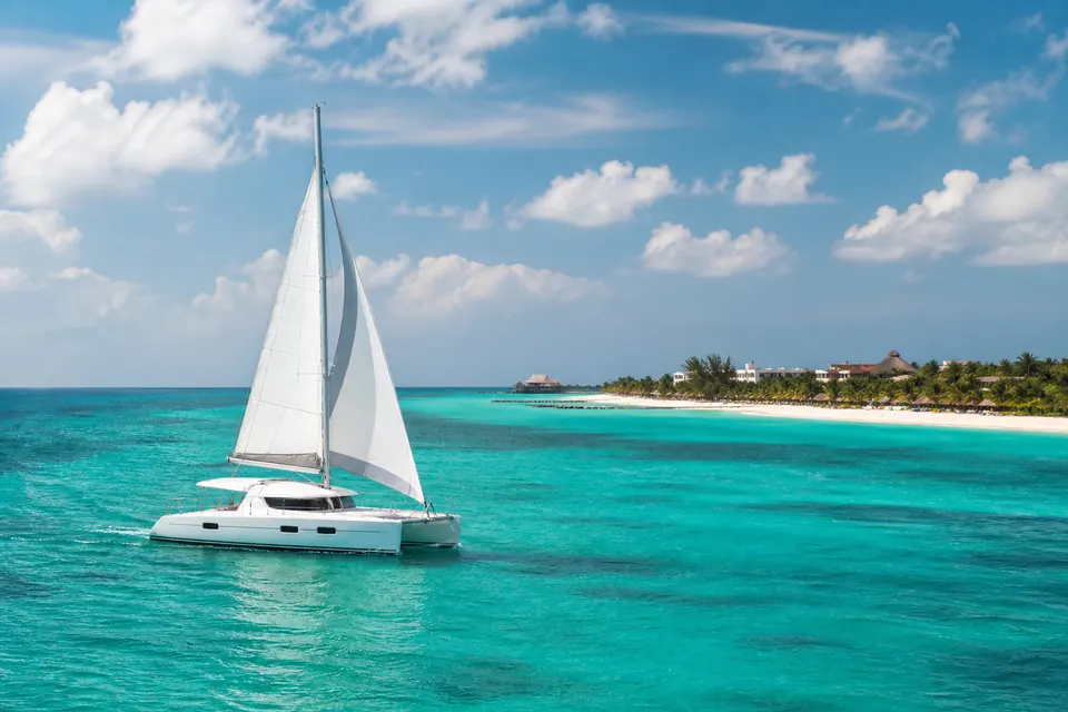 Catamarã navegando no mar turquesa próximo a Isla Mujeres