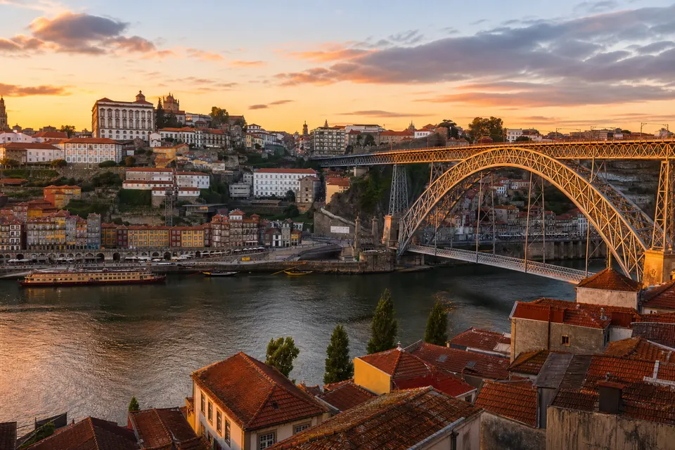 Porto e Ponte Dom Luís I iluminados pelo pôr do sol sobre o Douro